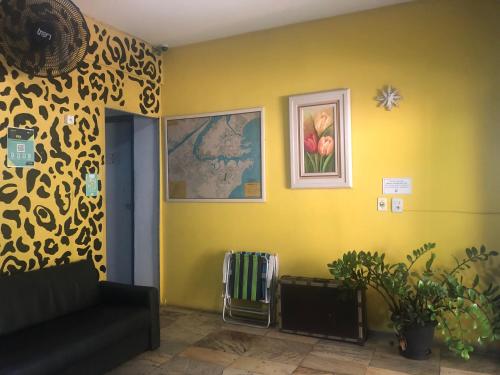 un soggiorno con divano e parete gialla di Onça da Praia Hostel a Vitória