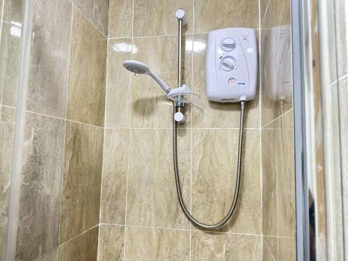 a shower with a shower head in a bathroom at Cosy, Charming 2-Bedroom Oasis in Ilkeston