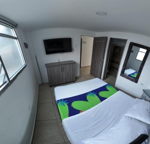 a small bedroom with a bed and a television at Hotel Plaza Paris in Calarcá