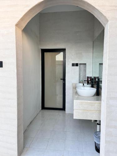 W białej łazience znajduje się umywalka i lustro. w obiekcie استراحة غزل w Medynie