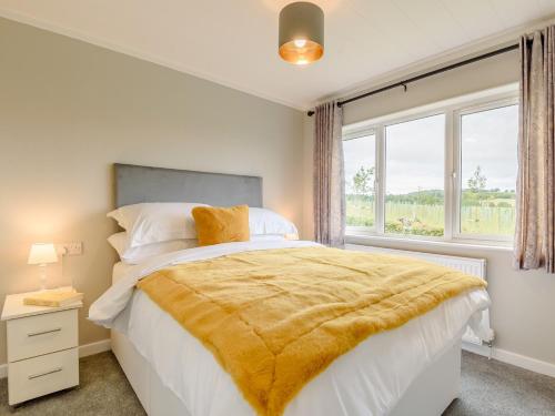 a bedroom with a bed with a yellow blanket on it at 2 Bed in Kinlet 92657 in Kinlet