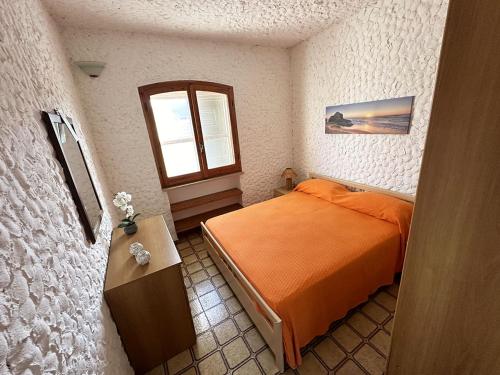 1 dormitorio con cama de color naranja y ventana en Appartamento vista mare a Maladroxia C227, en Maladroscia