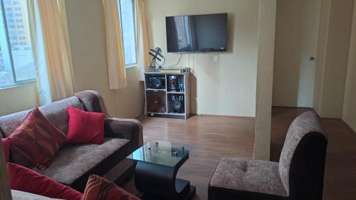 ein Wohnzimmer mit einem Sofa und einem TV in der Unterkunft RIMAC - EDMA SAC in Lima
