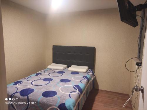 Schlafzimmer mit einem Bett mit einem schwarzen Kopfteil in der Unterkunft RIMAC - EDMA SAC in Lima