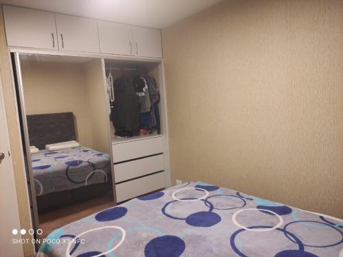 ein Schlafzimmer mit einem Bett und einem Schrank mit einem Spiegel in der Unterkunft RIMAC - EDMA SAC in Lima