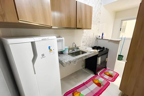 a kitchen with a white refrigerator and a sink at 103 - Apartamento Completo Para Até 5 Hóspedes in Patos de Minas