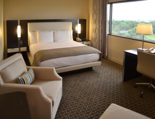 a hotel room with a bed and a chair and a window at DoubleTree by Hilton Hotel Houston Hobby Airport in Houston