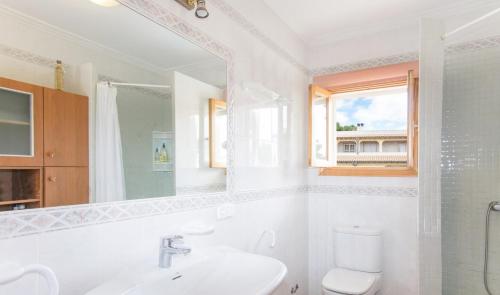 a bathroom with a sink and a toilet and a window at Playas de Mallorca in Muro