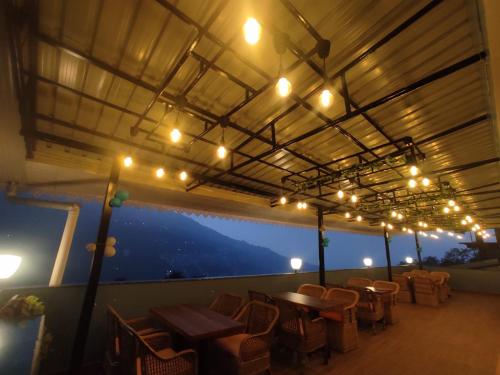a restaurant with tables and chairs and lights at Maplewood Hotel & Spa in Gangtok