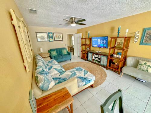uma sala de estar com um sofá e uma televisão em Saltwater Retreat of Redington Shores em St. Pete Beach