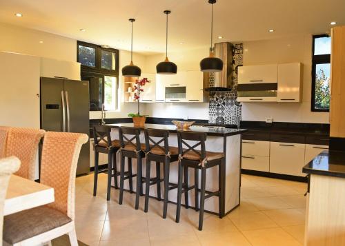 a kitchen with a island with bar stools at Villa Flor in Jarabacoa