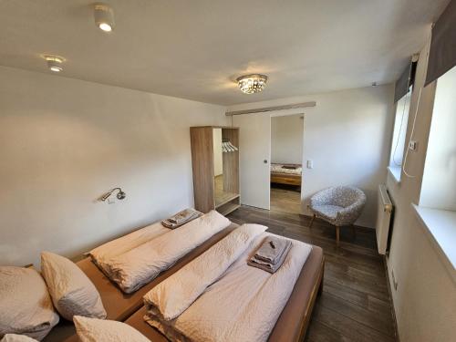a bedroom with two beds and a chair at Ferienwohnung am Wildpark HDH in Heidenheim an der Brenz