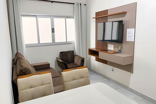 uma sala de estar com duas cadeiras e uma televisão em 104 - Apartamento Completo para até 7 Hóspedes em Patos de Minas