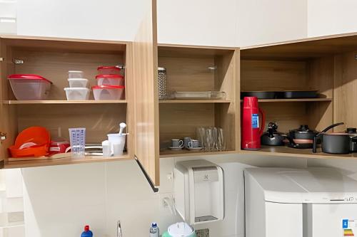 a kitchen with wooden cabinets with utensils at 104 - Apartamento Completo para até 7 Hóspedes in Patos de Minas