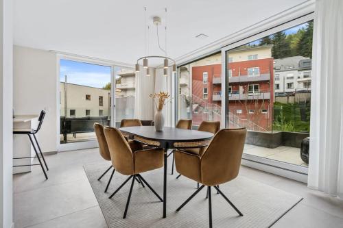 a dining room with a table and chairs and a large window at Luxury 2BR, Free Parking, Balcony in Luxembourg