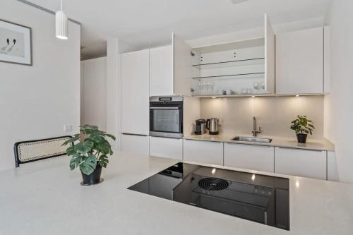 a kitchen with white cabinets and a black appliance at Luxury 2BR, Free Parking, Balcony in Luxembourg