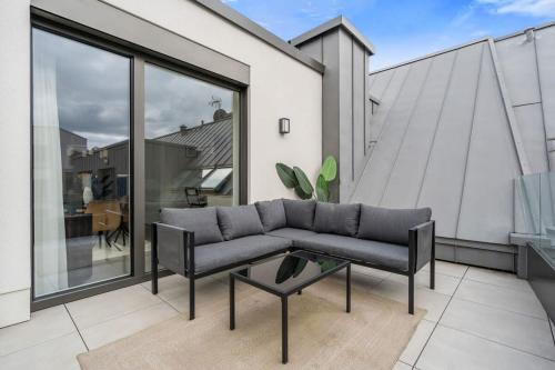 a living room with a couch and a table on a balcony at Luxury 2BR, Free Parking, Balcony in Luxembourg