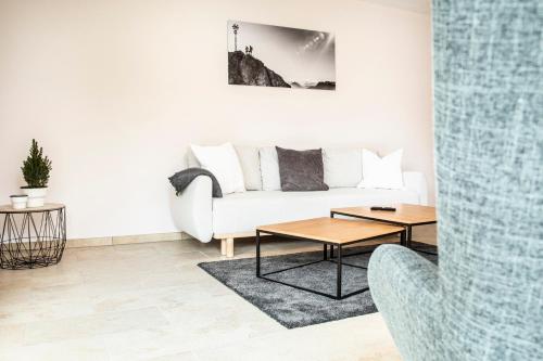 a living room with a white couch and a table at Ferienwohnungen "Zur Wally" in Garmisch-Partenkirchen