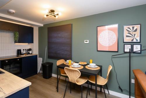 Benjamin Suite by Koya Homes - 3 Bedrooms - Cardiff في كارديف: مطبخ وغرفة طعام مع طاولة وكراسي