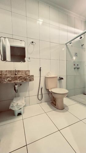 a bathroom with a toilet and a shower at Hotel Mediterrâneo in Lagarto