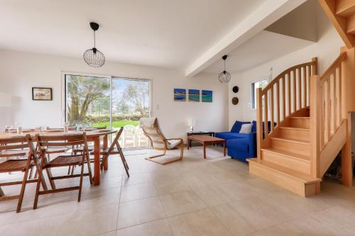 une salle à manger avec une table et un canapé bleu dans l'établissement Douce escale à Saint-Pierre-Quiberon, à Saint-Pierre-Quiberon