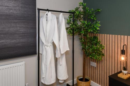 ein Badezimmer mit weißen Handtüchern auf einem Kleiderständer in der Unterkunft Benjamin Suite by Koya Homes - 3 Bedrooms - Cardiff in Cardiff