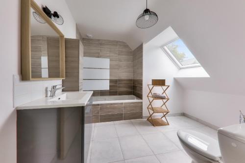 une salle de bain avec un lavabo et une baignoire dans l'établissement Douce escale à Saint-Pierre-Quiberon, à Saint-Pierre-Quiberon