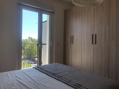 a bedroom with a bed and a large window at Finestra sul mare in Monfalcone