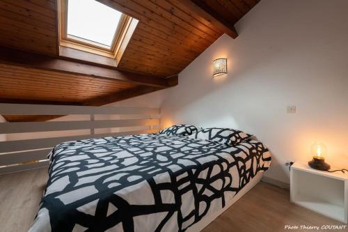 une chambre avec un lit noir et blanc et une fenêtre dans l'établissement Le Bel Ami proche Pontaillac, 3 pers, proximité centre, plage, commerce, à Royan