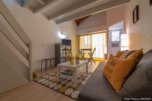 un salon avec un canapé et une table dans l'établissement Le Bel Ami proche Pontaillac, 3 pers, proximité centre, plage, commerce, à Royan