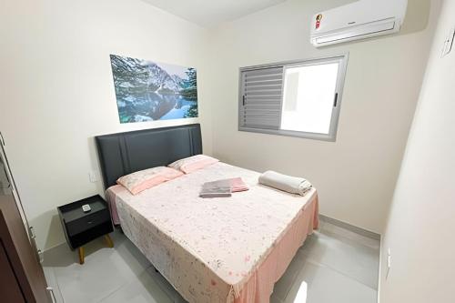 um quarto com uma cama e uma janela em 202- APARTAMENTO de 2 QUARTOS para até 5 HÓSPEDES em Patos de Minas