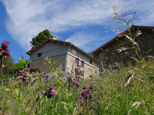 una casa in pietra con dei fiori davanti di la source d'en haut a Valcivières