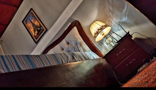 a bedroom with a mirror and a lamp and a bed at RAMS ENG ROME appartement meublé in Douala