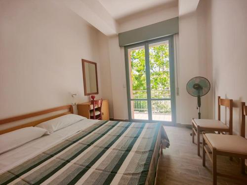 um quarto com uma cama e uma grande janela em Trilocale per Famiglie con Balcone em Cesenatico