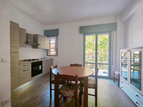 uma cozinha com mesa e cadeiras num quarto em Trilocale per Famiglie con Balcone em Cesenatico