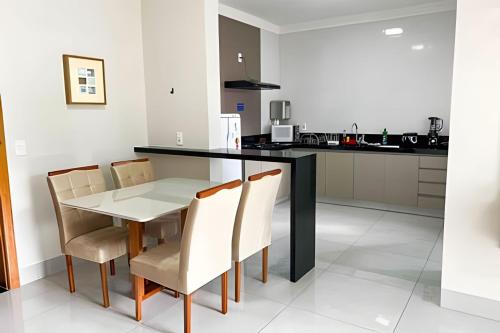M101 - Apartamento Completo Para Até 6 Hóspedes في باتوس دي ميناس: مطبخ مع طاولة طعام وكراسي