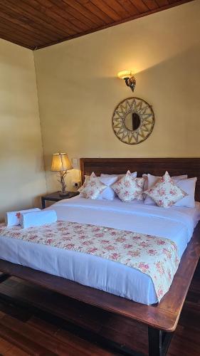 a bedroom with a large bed with white sheets and pillows at The Loris Manor in Nuwara Eliya