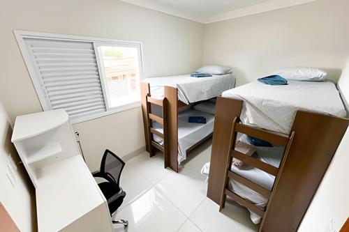 a small room with two beds and a window at M101 - Apartamento Completo Para Até 6 Hóspedes in Patos de Minas