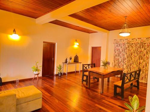 a living room with a table and a couch at The Loris Manor in Nuwara Eliya