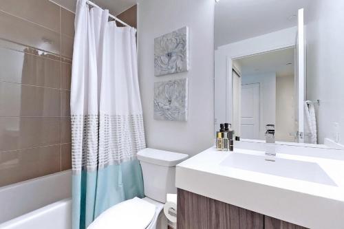 a white bathroom with a sink and a toilet at Cozy Suite in Heart of Downtown Toronto J7 in Toronto