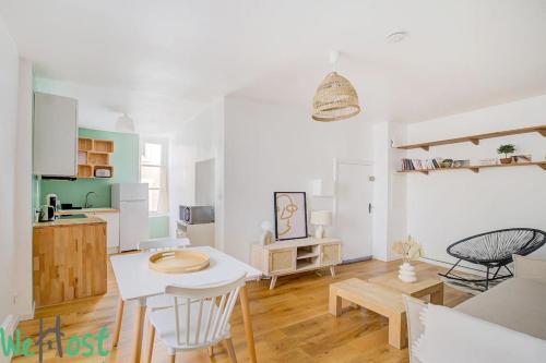 une cuisine et un salon avec une table et des chaises dans l'établissement Scribe bleu - Centre ville - moderne et calme, à Nantes