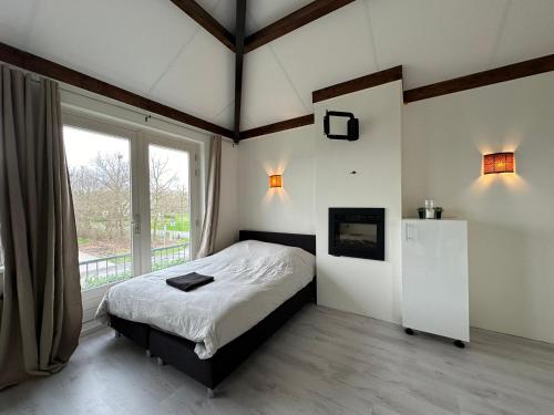 ein Schlafzimmer mit einem Bett und einem großen Fenster in der Unterkunft Groot vakantiehuis nabij Amsterdam inclusief jacuzzi in Zeewolde