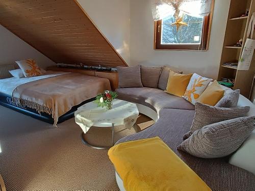 ein Wohnzimmer mit einem Sofa und einem Bett in der Unterkunft Ferienwohnung Hey in Elgersburg