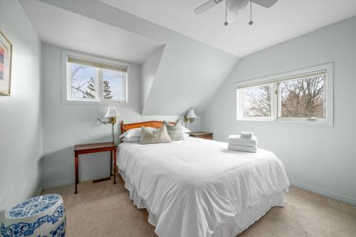 1 dormitorio blanco con 1 cama y 2 ventanas en Green Leaves - Family Getaway in PEC, en Bloomfield