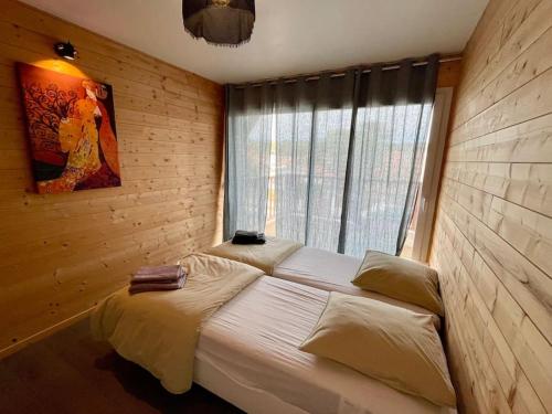 - une chambre avec un grand lit et une fenêtre dans l'établissement Welcoming new architects house with jacuzzi, à Hourtin