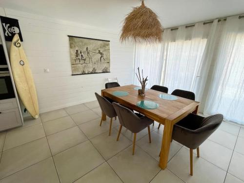 a dining room with a wooden table and chairs at Welcoming new architects house with jacuzzi in Hourtin