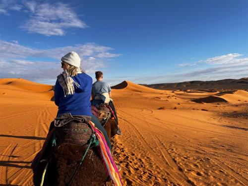 two people riding on horses in the desert at Sahara Berber Camp - Mhamid Discovery Camp in Mhamid el Rhozlane