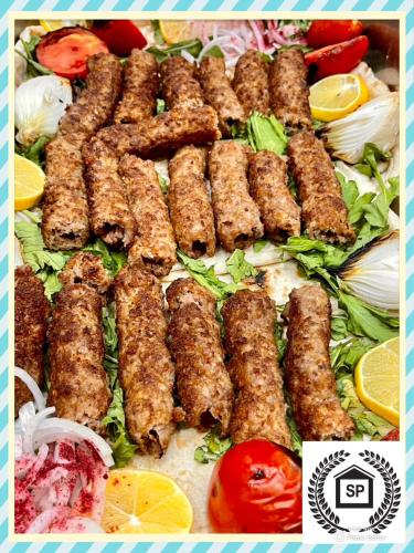 a bunch of food on a table with vegetables at Al-Sadier Place Hotel & Restaurant in Baghdad