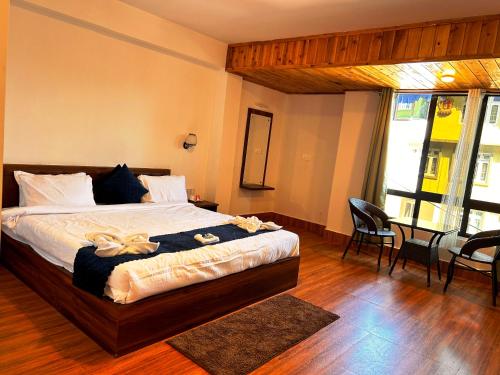 a bedroom with a bed and a table and chairs at DISHA SILVER PEAK Hotel in Pelling