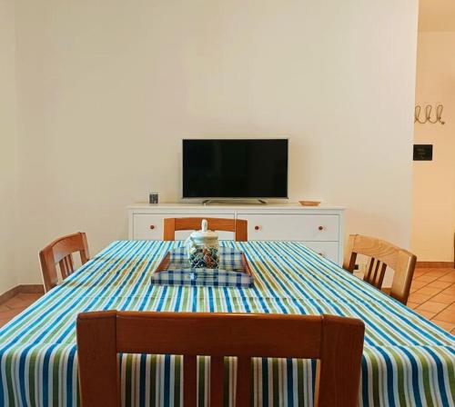 comedor con mesa con sillas y TV en Casa Grottammare-Sea Relax Holiday Home-, en Grottammare